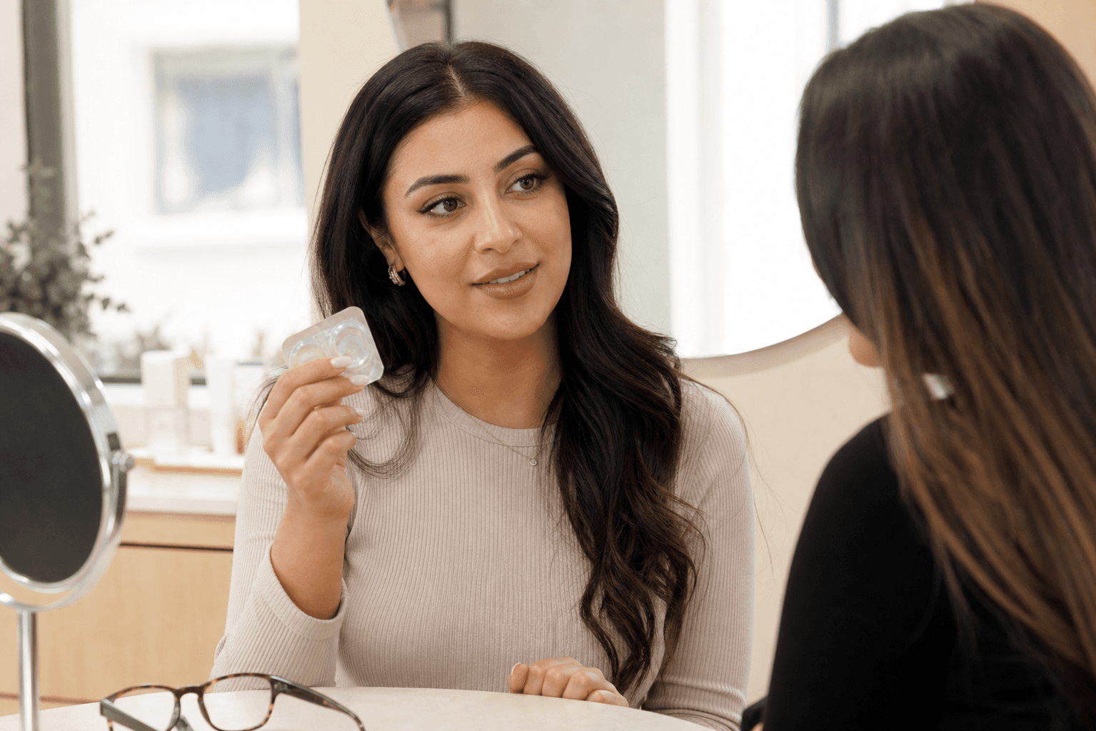 Contact lens wearer discussing eyelash extensions during a beauty consultation
